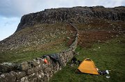 Stavíme stan v závětří mezi dvěma srázy, chránění kamennou zídkou. Chystáme večeři a popíjíme Whisky. Navíc je poblíž rozpadlá dřevěná chajda a tak máme i dostatek dřeva na večerní táborák. : Skotsko, Skye
