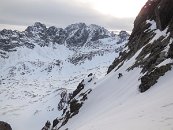 Jeňa traverzuje do centrálního výstupového žlabu. Zcela vzadu vystupuje zpoza hřebene Gerlachovský štít.