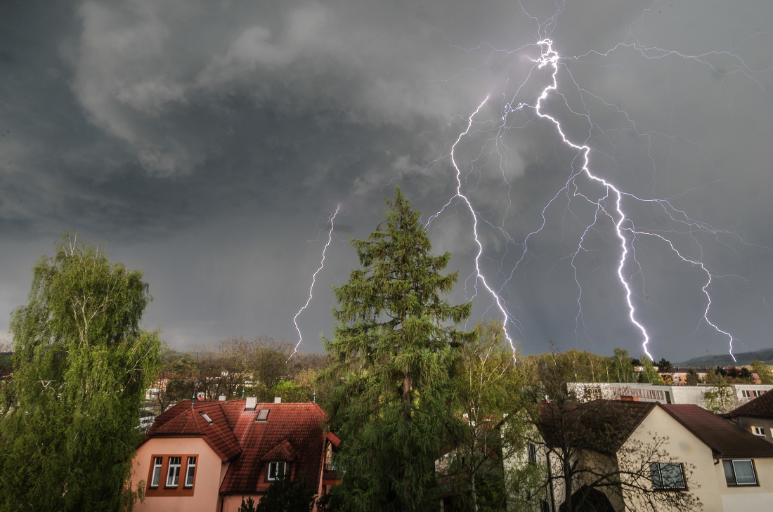 Z hrozivě vypadající základny bouřkového mraku cumulonimbus (húlava) vystřelují mohutné blesky.